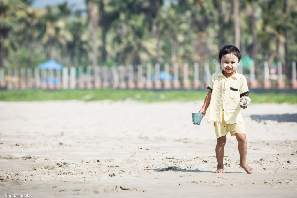 Child plays with sand on Ngwe Saung beach